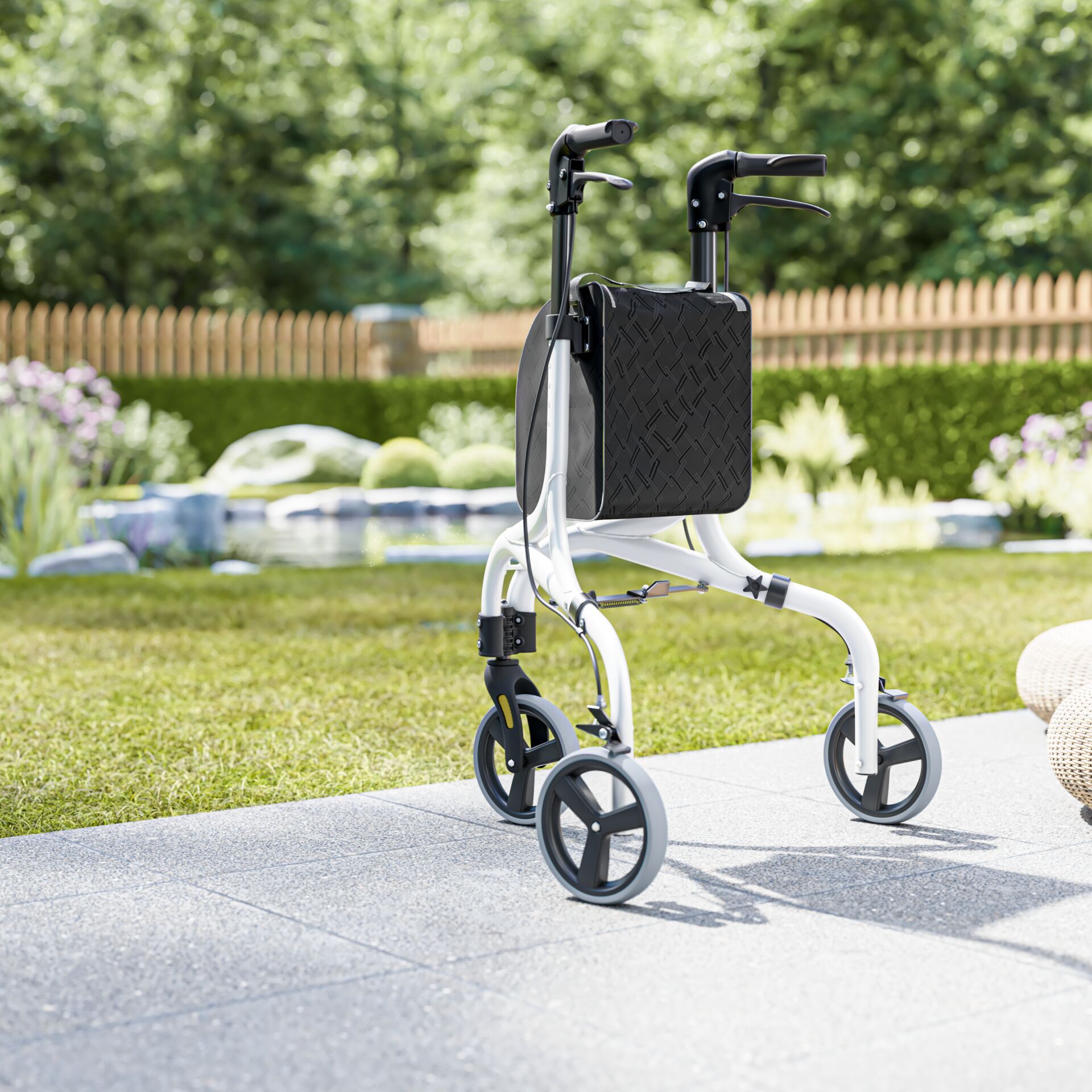 Ein moderner Rollator steht auf einer Terrasse im Garten mit grüner Umgebung im Hintergrund.