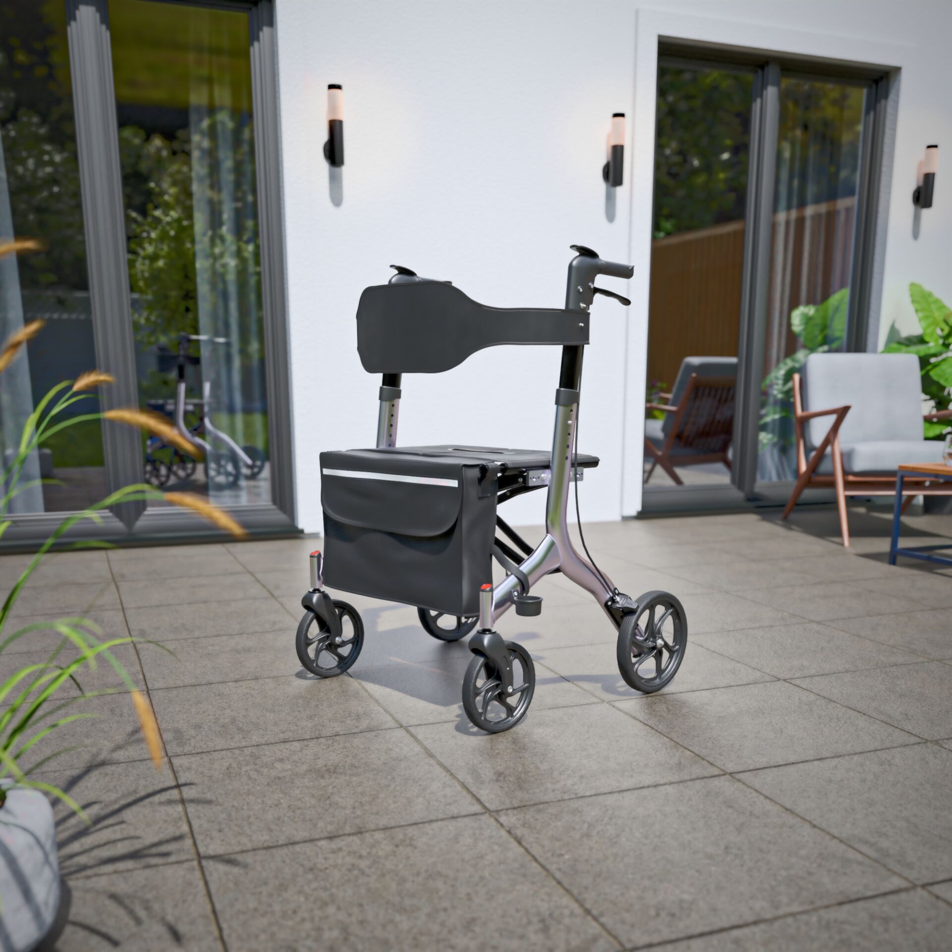 Ein moderner Rollator steht auf einer Terrasse. Im Hintergrund sind eine Glasschiebetür, eine Wand mit Außenlampen und eine gemütliche Sitzecke erkennbar.
