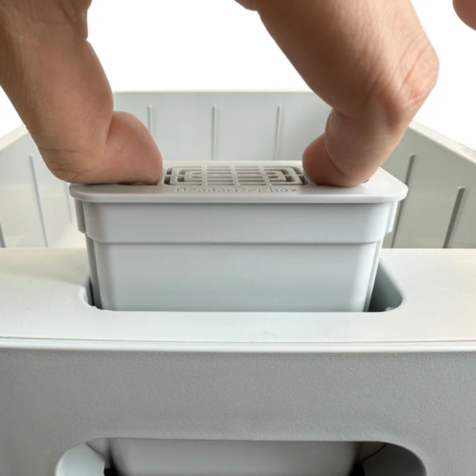Nahaufnahme einer Hand, die einen Ersatzfilter in einen Luftreiniger einsetzt