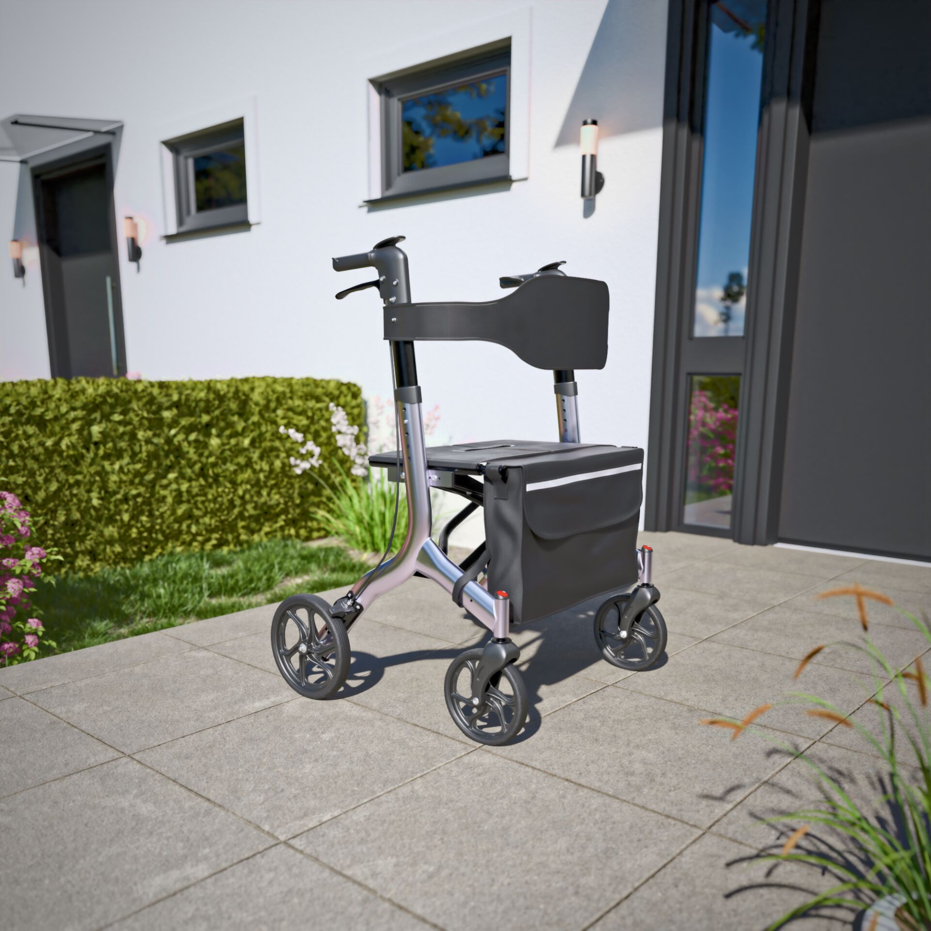 Ein moderner Rollator steht auf einer Terrasse vor einem zeitgenössischen Wohnhaus mit gepflegtem Garten im Hintergrund.