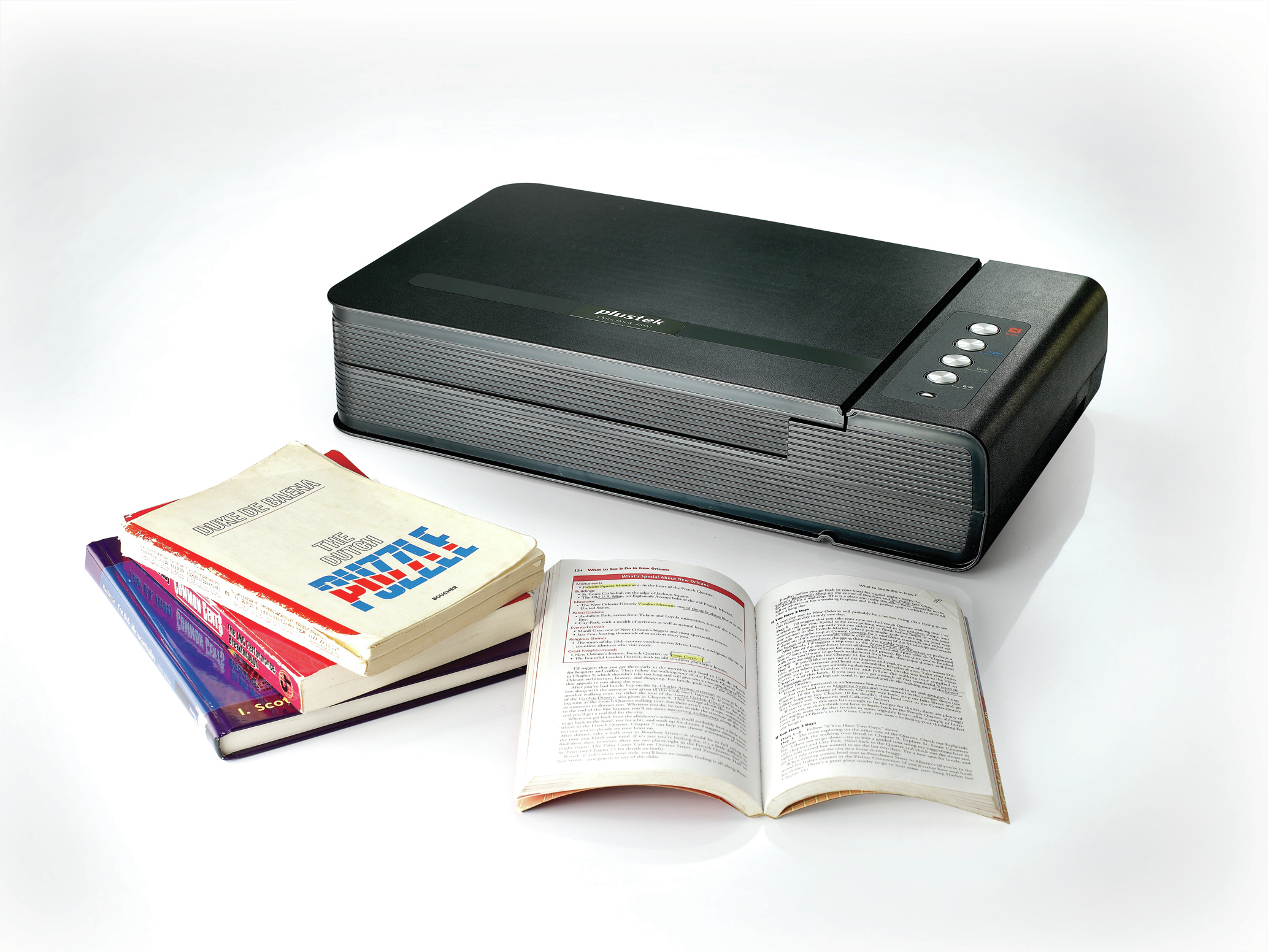 Ein flacher Scanner steht neben einem Stapel Bücher, einschließlich eines offenen Buches, auf einem weißen Hintergrund.